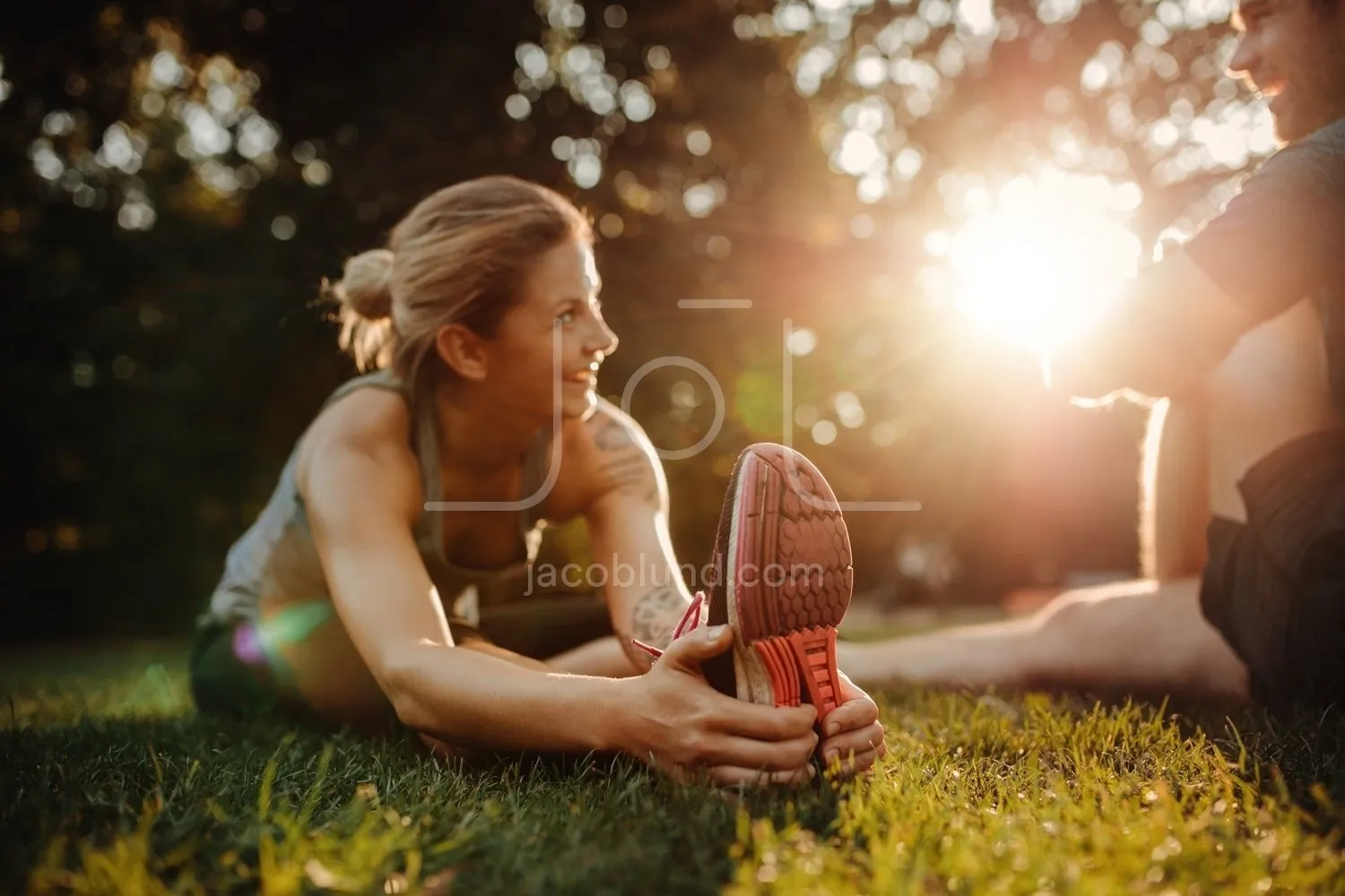 Beautiful young woman exercising at park with man